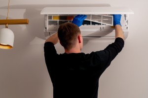 man inspecting hvac unit