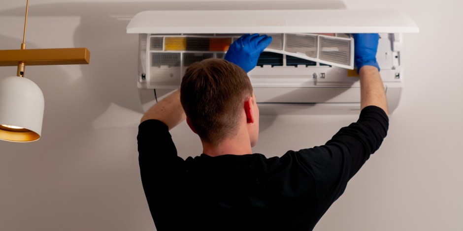 man inspecting hvac unit